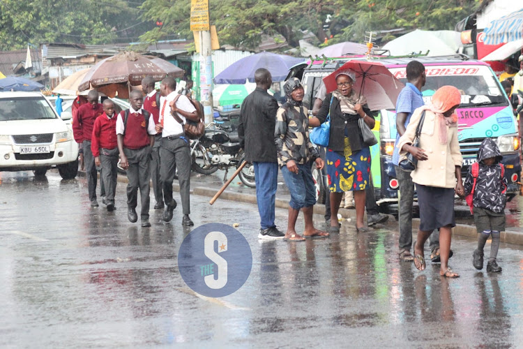 Residents brave the rain to reach their destinations on March 14, 2023