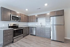 Kitchen with dark brown cabinets, stainless steel appliances, granite countertop, dark wood floors, recessed lights