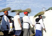 Women carry grass to use on the floor for sitting during their annual pilgrimage at eKhanana mountain in Ndwedwe.