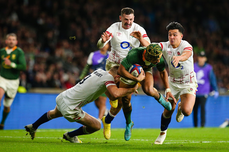 Wing Kurt-Lee Arendse is scragged by England's Jack van Poortvliet, Marcus Smith and Jonny May during the Springboks' 27-13 win at Twickenham in London on November 26 2022. File photo.