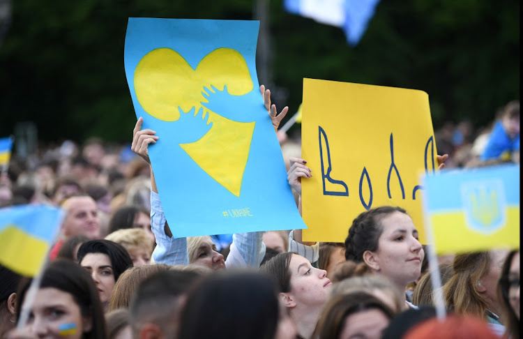 People hold banners as they attend a charity telethon in support of Ukraine "Save Ukraine - #StopWar", amid Russia's invasion of Ukraine, in front of the Brandenburg Gate, in Berlin, Germany May 29, 2022.