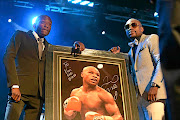 Vusi Mathibela, left, with boxer  Floyd Mayweather at a gala dinner in 2014. Now  the nightclub owner is  allegedly linked to the murder of Wandile Bozwana.