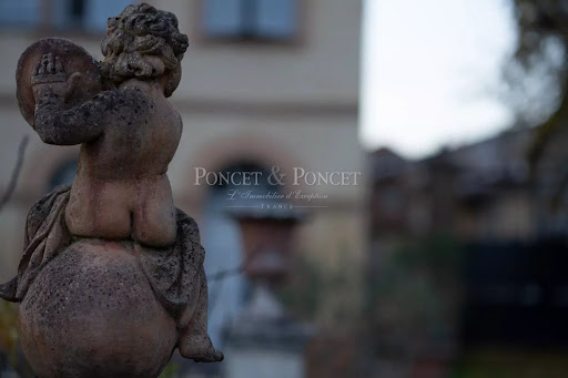 Stone statue of an angel on a globe in this luxury castle for sale in Verdun-sur-Garonne ($1,025,410 - 1,150 m²)