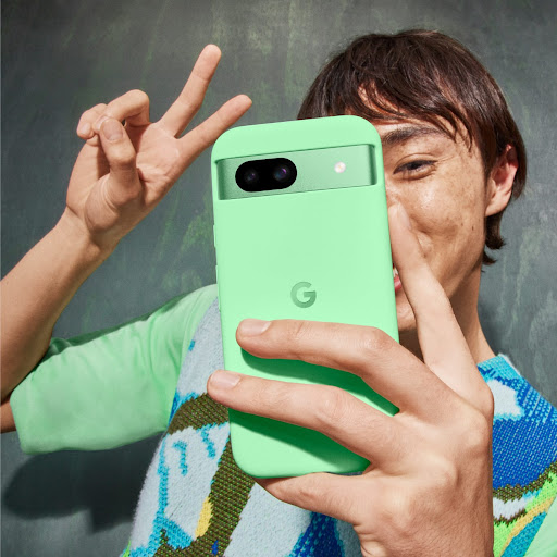 Une personne pose pour un selfie avec son Pixel 8a couleur Vert Aloe.