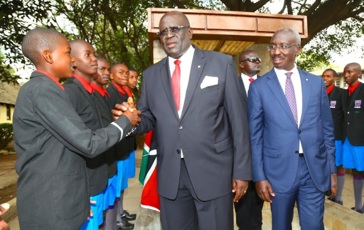 Education CS George Magoha greets Form One students accompanied by Starehe Boys Centre director Josephat Mwaura