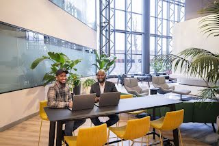 The two male founders of Ilmiya sitting at a desk with their laptops