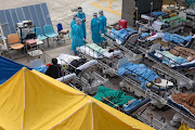 Patients displaying Covid-19 symptoms at a temporary triage area next to the emergency department at the Caritas Medical Center hospital in Hong Kong, China, on February 16 2022.