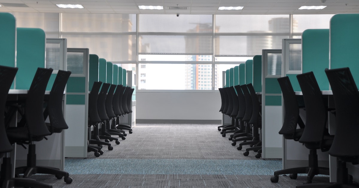Symmetrical aisle of office desks and chairs