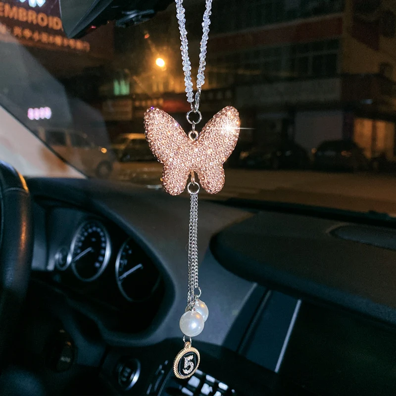 Pingente de carro com laço de metal, pérola e diamante. Adicione luxo e requinte ao seu veículo. Estilo e elegância em cada viagem.