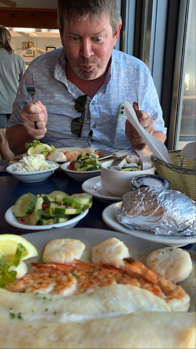 Broiled seafood with cucumber salad and baked potato