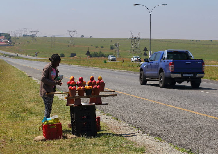 An unidentified young girl sells mangoes to passing motorists. File photo.