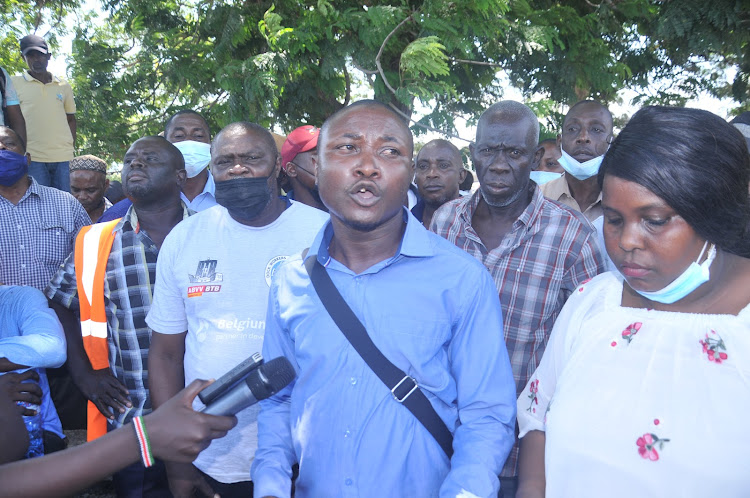 Dock Workers Union Shop Steward Justine Angore with other union members address journalists outside the Port of Mombasa on Tuesday.