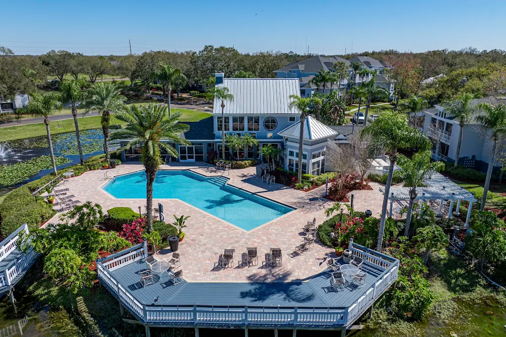 Drove view of the community featuring the pool, clubhouse and pond.