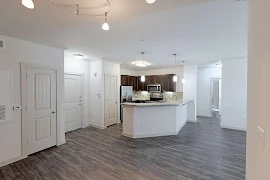 Dining area open to the kitchen area with a breakfast bar and wood-inspired flooring throughout 