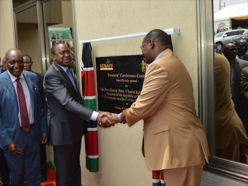 President Uhuru Kenyatta shakes hands with Chief executive officer John Mutunga of Kenya National Farmers' Federation during the official opening of farmers conference centre in Kikuyu./FILE