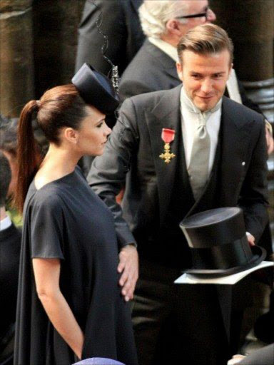 English footballer David Beckham pats his wife Victoria's baby bump as they arrive at Westminster Abbey in London, for the royal wedding of Britain's Prince William and Kate Middleton.