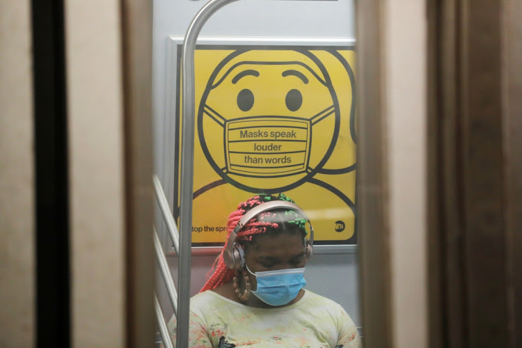 A commuter wears a mask under public safety signage as cases of the infectious coronavirus Delta variant continue to rise in New York City, New York, US, on July 26, 2021. Picture: REUTERS/ANDREW KELLY