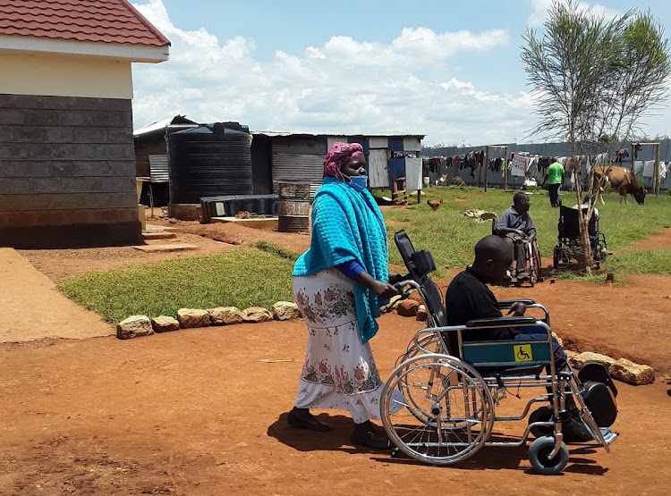 Judith Korir pushes the wheelchair of one of the children at the rehabilitation centre