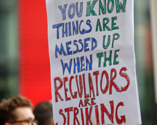 A member of Unite the Union holds a placard as they begin strike action at the Financial Conduct Authority (FCA) in London, Britain, May 4, 2022.