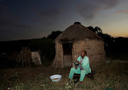 Mpiyesende Ngcobo, 80, uses a homemade iron pestle and mortar to crush peanuts outside his secluded hut, located in the dense brush on the outskirts of Nongoma in northern KwaZulu-Natal.