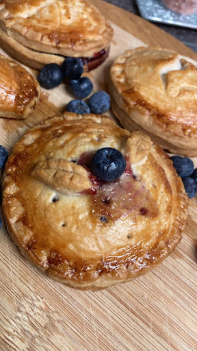 Blueberry Handpie on wooden cutting board drizzled with wild honey