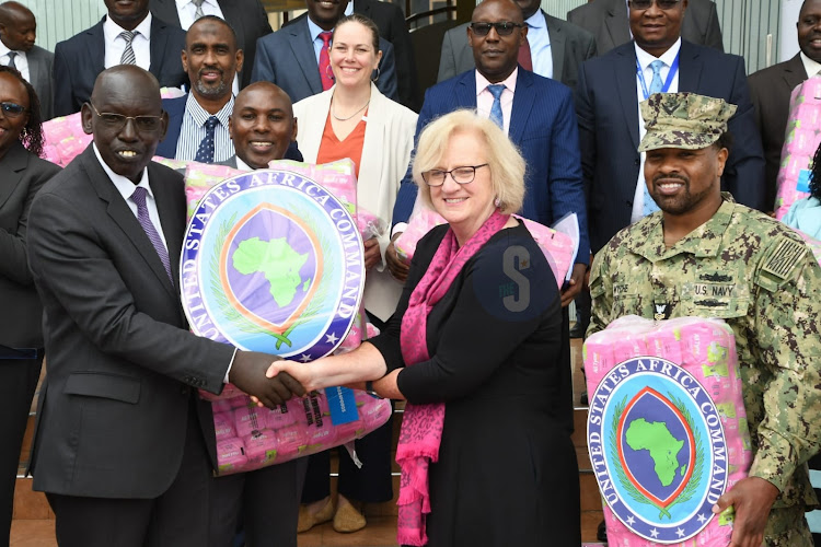 Education Principal Secretary Belio Kipsang receives a pack of sanitary towels from US Embassy Consular General Deborah Miller during the handing over of sanitary towels donated to the ministry of education by US government (USAID KENYA EAST AFRICA) at the KICD on Wednesday 20, 2024