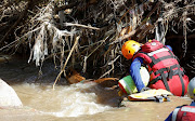 Warrant Officer Andre Smit and his tracking dog Zeus search for bodies after heavy rains caused flooding on the Mzinyathi River near Durban, South Africa, April 19, 2022.