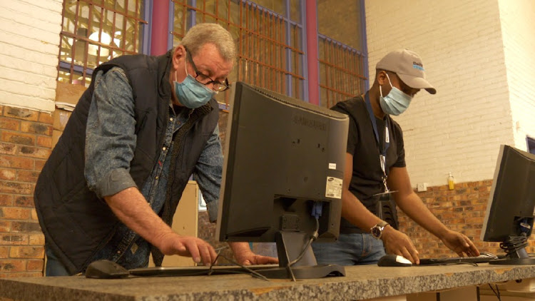 John Goodrich, left, setting up the computers he repaired for Unathi Secondary School. As part of their Mandela Day Initiative, the Daily Dispatch and Johnson and Johnson partnered with Goodrich to collect and fix computers for the school.