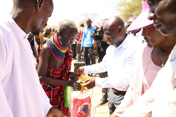 Turkana Deputy Governor John Erus (Right) and Evangelist Ezekiel Odero of the New Life Church, Mombasa. distributing relief food to residents of Kapua, Kalokol ward Turkana Central