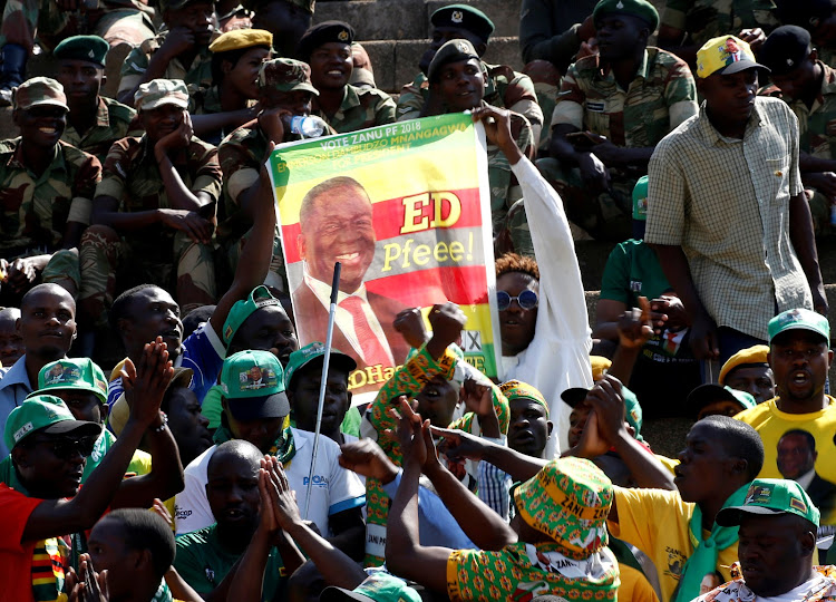 Supporters of Zimbabwe's President Emmerson Mnangagwa hold a poster during the national 38th Heroes' Day Commemorations at the Heroes Acre in Harare, Zimbabwe, August 13,2018.