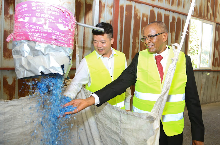 Weeco Recycling Company director Wang Zhangyin walks Kenya PET Recycling Company chairman John Waithaka through the Weeco recycling plant in Athi River in April 2019