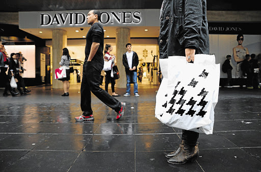 IN THE BAG: A customer carries a shopping bag featuring the houndstooth branding of David Jones outside the retailer's Bourke Street store in Melbourne, Australia, on Wednesday. South Africa's Woolworths agreed to buy David Jones for A$2.15-billion (R21-billion)