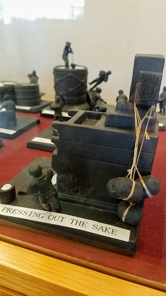 Figures showing the multiple steps in the process of brewing sake, in a display case when visiting Gekkeikan USA in Folsom