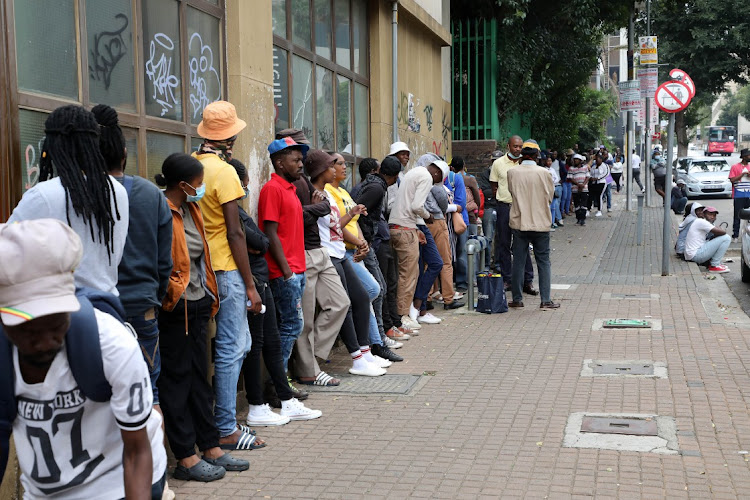 People queue for the R350 grant payment at the Braamfontein post office in Johannesburg. The social development department says everyone must apply for the grant, even those who had been receiving it previously. File photo.