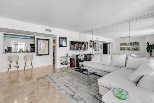 Modern living room with white sofa and bar in this luxury property for sale in Miami Beach ($2,300,000)