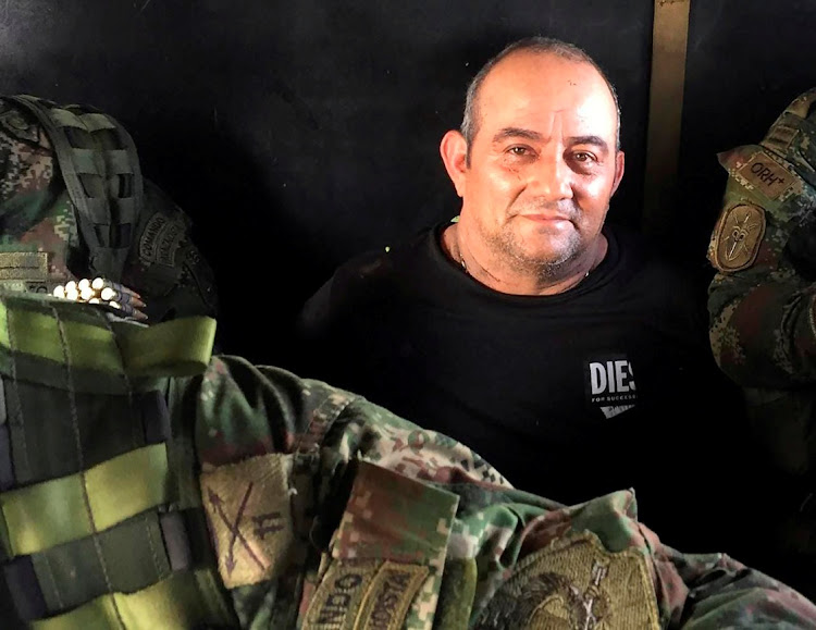 Dairo Antonio Usuga David, alias "Otoniel", top leader of the Gulf clan, poses for a photo while escorted by Colombian military soldiers. Picture: COLOMBIAN DEFENSE MINISTRY/REUTERS