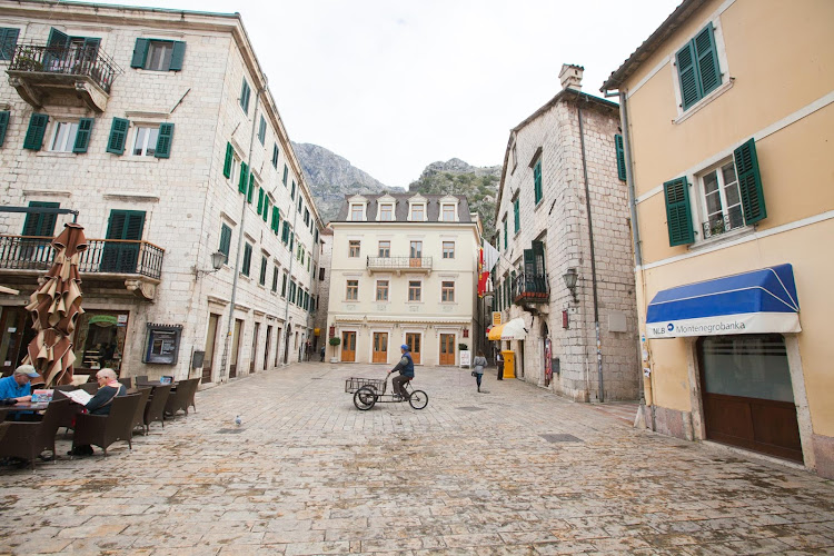 A square in Kotor's Stari Grad, or Old Town, lined with elegant stone houses and thin lanes. 