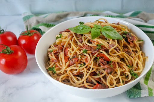 A bowl of Skillet Fresh Prosciutto, Tomato, and Basil Pasta.