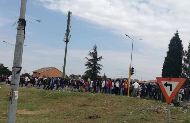 Protesters from Munsieville throw stones at a police vehicle and attempted to burn the Satellite police station.