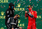 Race winner Lewis Hamilton of Great Britain and Mercedes GP celebrates winning a 7th F1 World Drivers Championship with Third placed Sebastian Vettel of Germany and Ferrari on the podium during the F1 Grand Prix of Turkey at Intercity Istanbul Park on November 15, 2020 in Istanbul, Turkey.