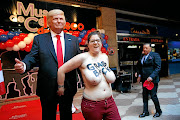 A  FEMEN activist protests with the wax figure of  US President Donald Trump in Madrid in January 2017.