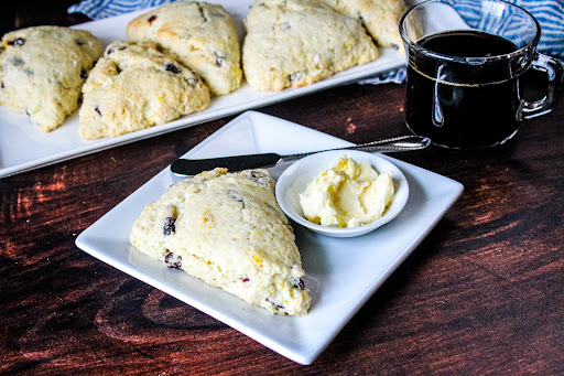 Cranberry Orange Ginger Scones on a plate with butter.