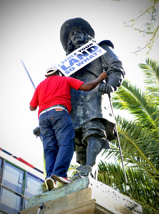 Sulyman Stellenboom hangs a poster on the Jan van Riebeeck statue in 2015 in Cape Town.