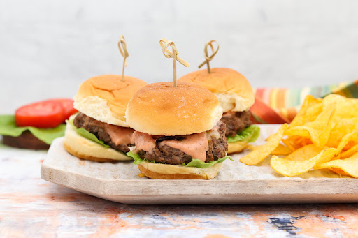 A platter of Mini Sliders Burgers and Special Sauce with chips.