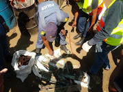 Police examine loot found at a scrap metal dealer's yard in Isipingo, south of Durban.