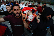 Mourners carry the body of a Palestinian who died during an Israeli settler attack on their village of al-Mughayyir, in Ramallah, in the Israeli occupied West Bank on April 12 2024.