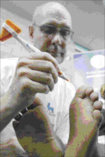 DOES THIS HURT? Podiatrist Andrew Clarke from Witwatersrand University tests sensation in the feet of a patient from Kidd's Beach on World Diabetes Day this week. Picture: PHILLIP NOTHNAGEL. Pic: Phillip Nothnagel. 15/11/05.©DD.