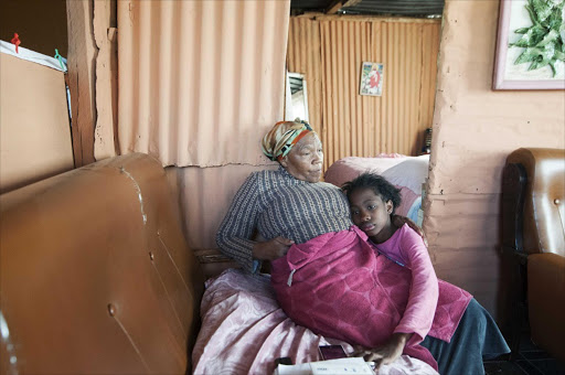 July 16, 2016. HOPEFUL: Miriam Tobias with her granddaughter. Miriam (74) hopes that her son Papi, a Boiketlong community activist who disappreared in February, will one day walk through the doors of his shack, which she has since moved into PHOTO: THULANI MBELE © Sowetan