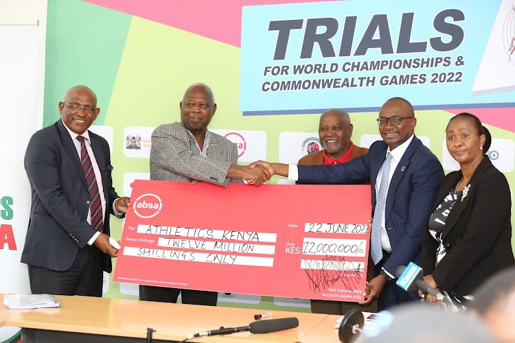 Athletics Kenya officials led by President Jackson Tuwei receive a dummy cheque from Absa Kenya Marketing director Moses Muthui at Riadha House