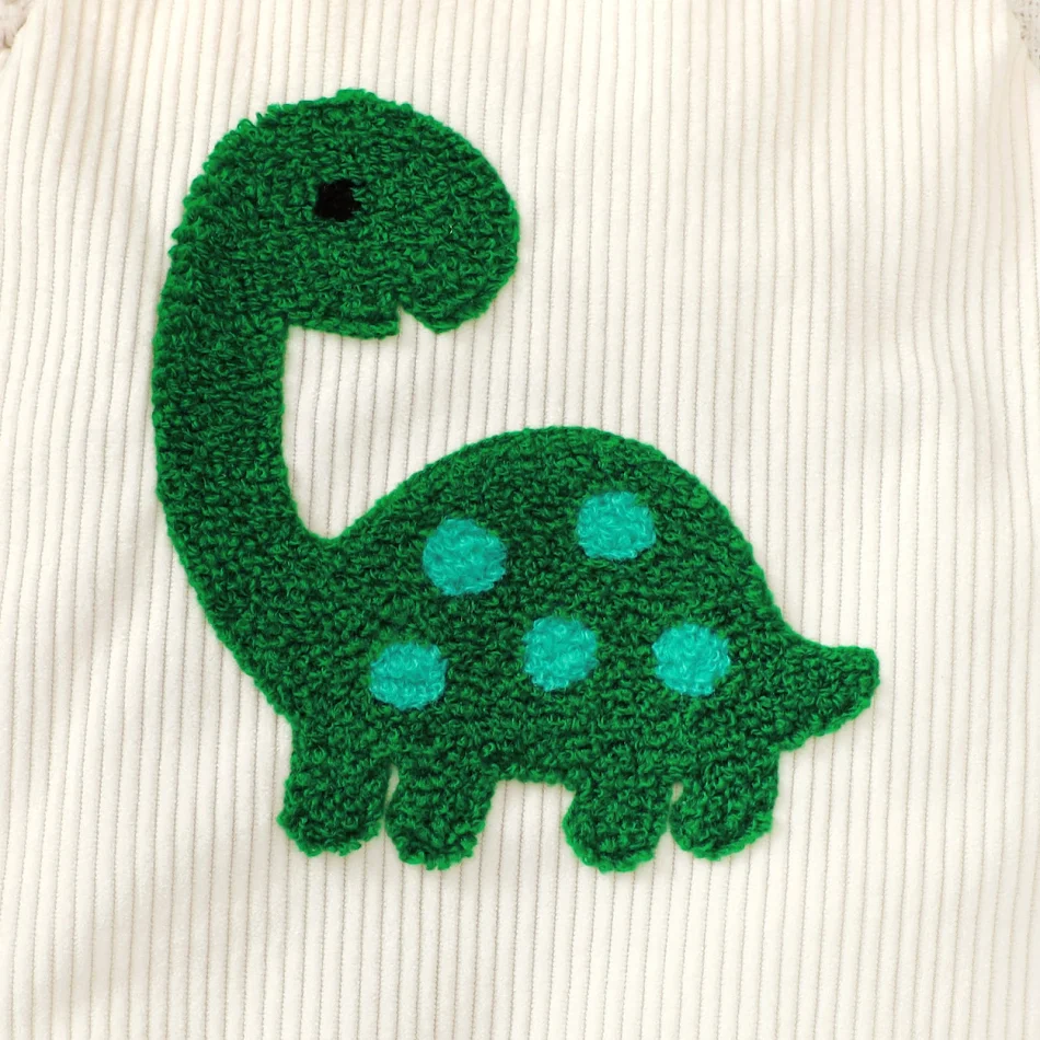 Barboteuse-sling brodée en velours côtelé vert pour bébé, motif tortue, une serviette de bain et un vêtement pratique.